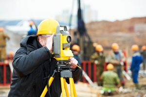 worker doing a land survey with a theodolite