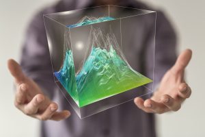 man with arms outstretched with a cube displaying topography 