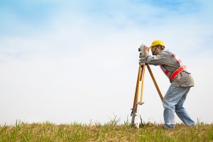 Surveyor engineer making measure onf a field