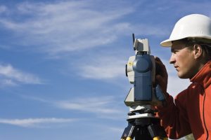 a land surveyor using an engineering instrument 