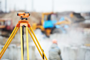 land surveyor equipment with out of focus construction in background