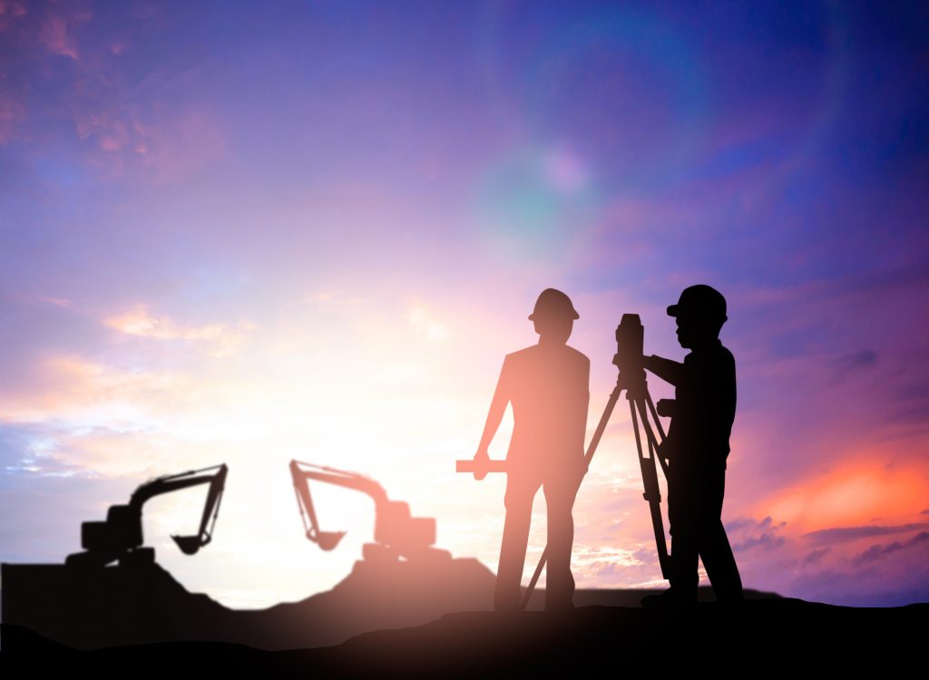 silhouette survey engineer working  in a building site over Blurred construction worker on construction site