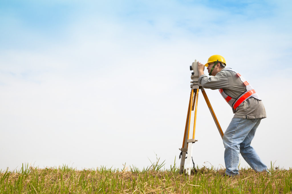 a land surveyor working with a theodolite