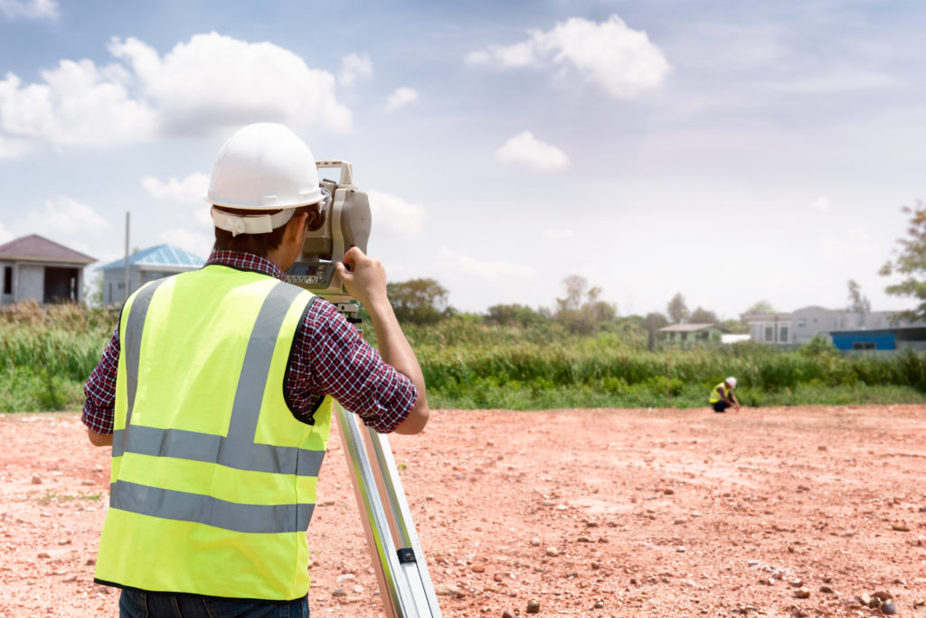 a man using a theodolite to check land