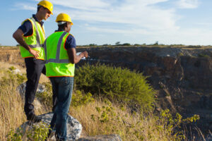 two male surveyors working at mining site